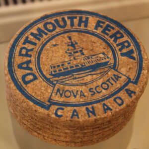 a cork coaster with blue screen print image of a ferry boat with the text Dartmouth Ferry Nova Scotia Canada