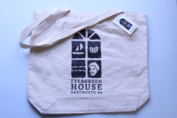 photo of an off-white canvas tote bag with a black and white screen printed design and the text Evergreen House Dartmouth NS